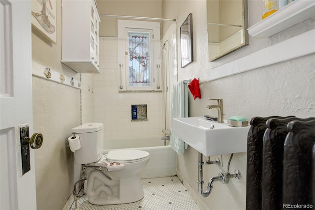 full bathroom featuring sink, tiled shower / bath, tile patterned floors, and toilet