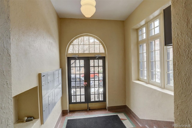 entryway with a mail area, french doors, and a healthy amount of sunlight