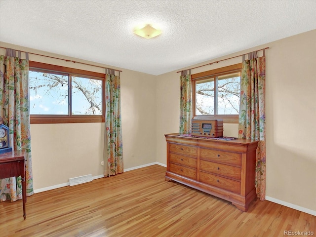12798 Tomahawk Rd, Parker, CO 80138 - bedroom with baseboards, light wood-style flooring, visible vents, and a textured ceiling