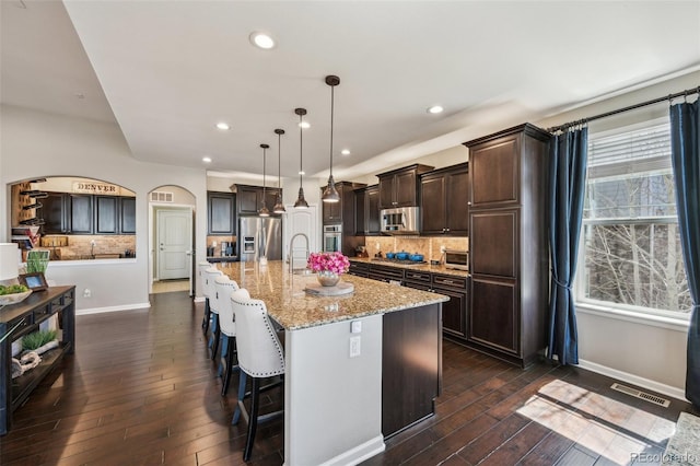 27423 E Euclid Dr, Aurora, CO 80016 - kitchen featuring appliances with stainless steel finishes, dark brown cabinetry, dark wood-style floors, light stone counters, and recessed lighting