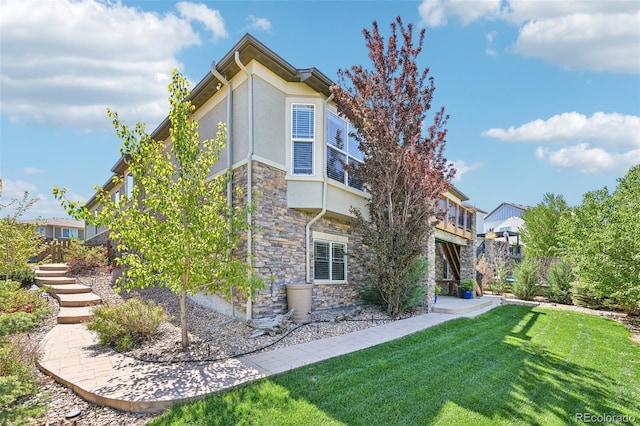 27423 E Euclid Dr, Aurora, CO 80016 - rear view of house featuring stone siding, a lawn, stairway, and stucco siding