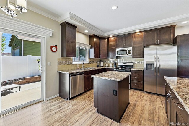 6231 Indian Paintbrush St Unit 214, Frederick, CO 80530 - kitchen with appliances with stainless steel finishes, a sink, ornamental molding, dark brown cabinetry, and tasteful backsplash
