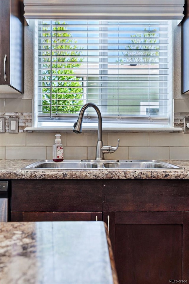6231 Indian Paintbrush St Unit 214, Frederick, CO 80530 - detailed view of a sink, dark brown cabinetry, decorative backsplash, and light countertops