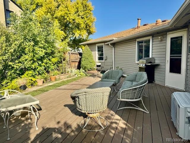 wooden deck with outdoor lounge area and area for grilling