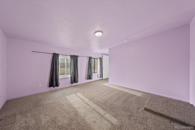 carpeted empty room featuring a textured ceiling