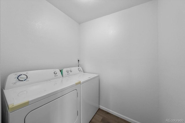 clothes washing area featuring washing machine and dryer and dark wood-type flooring