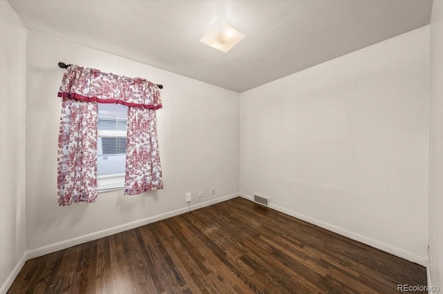 empty room with dark hardwood / wood-style flooring