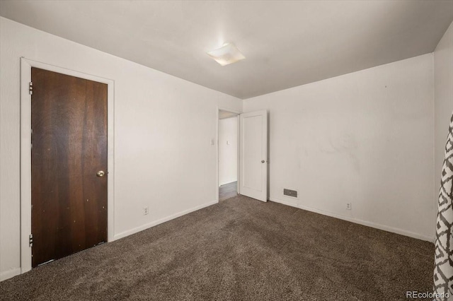 unfurnished bedroom featuring a closet and dark carpet