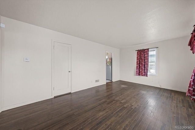 empty room with dark hardwood / wood-style flooring