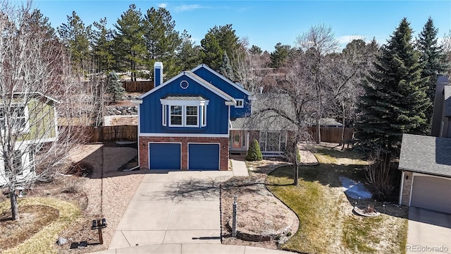 view of front facade with brick siding, concrete driveway, fence, and a garage