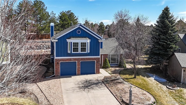 view of front of property featuring an attached garage, brick siding, board and batten siding, and driveway