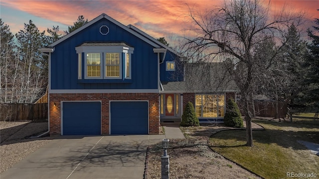 view of front of home featuring board and batten siding, fence, brick siding, and driveway