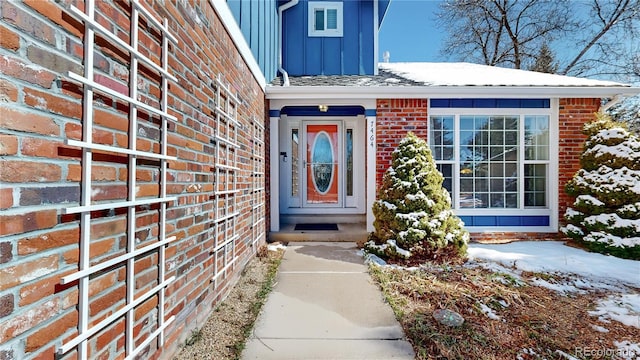 entrance to property featuring board and batten siding and brick siding