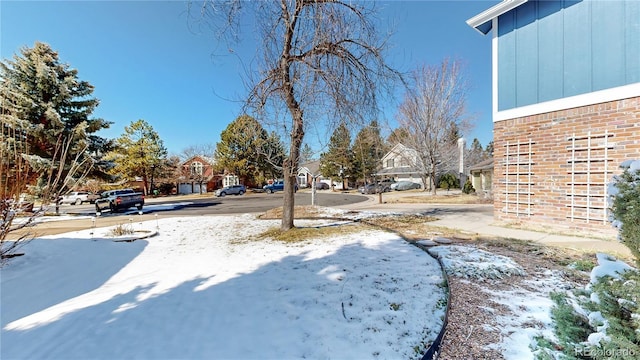 yard layered in snow with a residential view