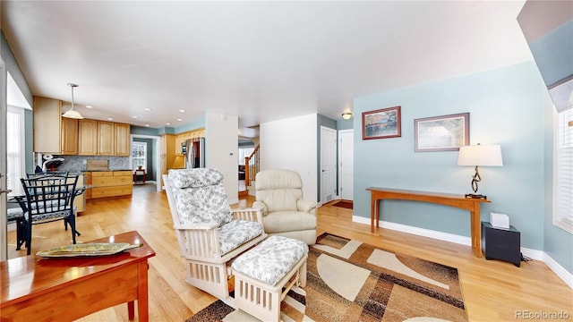 living room featuring recessed lighting, baseboards, and light wood-style flooring