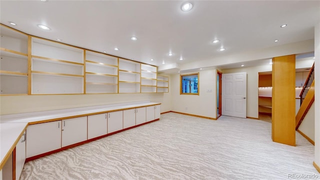 finished basement with light carpet, recessed lighting, stairs, and baseboards