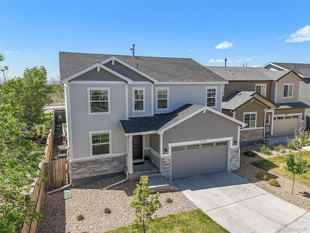5078 S Quail St, Littleton, CO 80127 - view of front of property featuring concrete driveway, roof with shingles, stone siding, and a garage