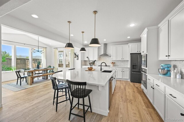 5078 S Quail St, Littleton, CO 80127 - kitchen featuring wall chimney exhaust hood, oven, light countertops, decorative backsplash, and light wood-style flooring