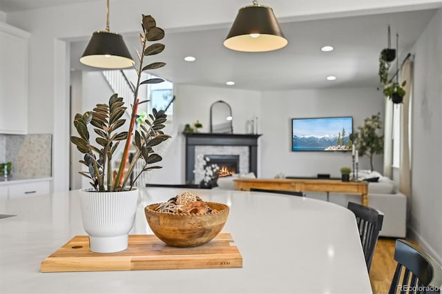 5078 S Quail St, Littleton, CO 80127 - kitchen with recessed lighting, white cabinetry, a warm lit fireplace, decorative light fixtures, and backsplash
