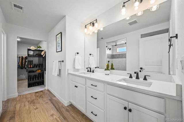 5078 S Quail St, Littleton, CO 80127 - full bath with double vanity, a tile shower, wood finished floors, and a spacious closet