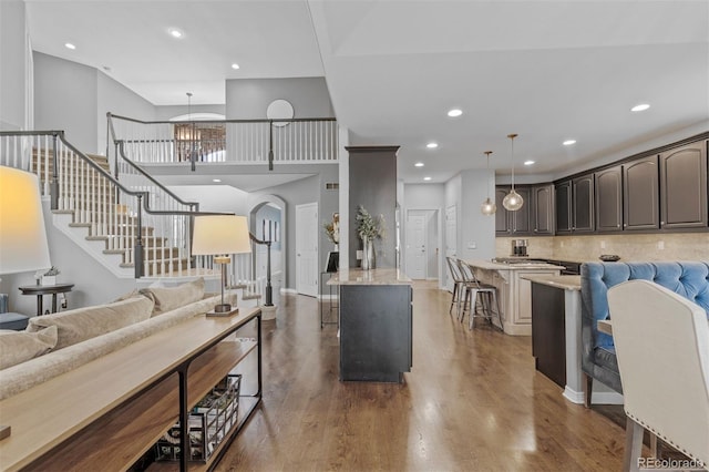 living area with stairway, recessed lighting, and wood finished floors