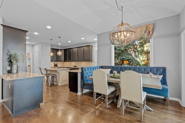 dining area featuring breakfast area, recessed lighting, baseboards, an inviting chandelier, and wood finished floors