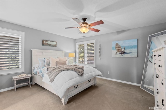 bedroom featuring light colored carpet, baseboards, and a ceiling fan