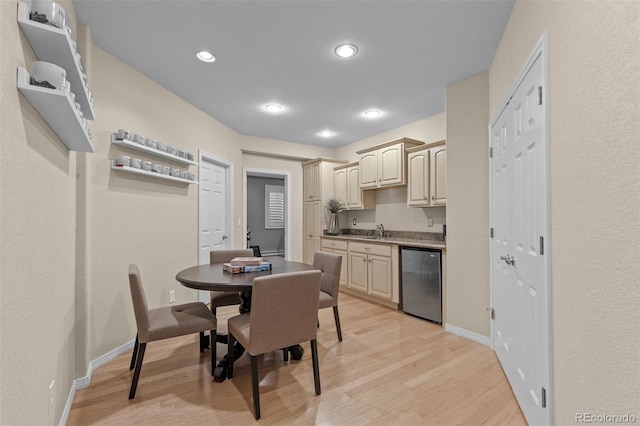 kitchen featuring a sink, light wood-type flooring, baseboards, dishwasher, and recessed lighting