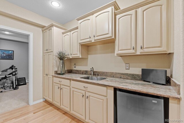 kitchen with fridge, cream cabinetry, and a sink