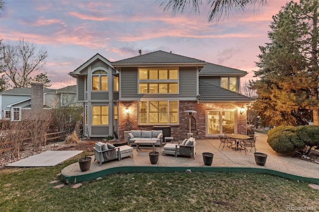 rear view of house with fence, brick siding, a yard, a patio, and an outdoor living space