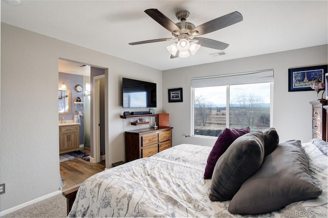 bedroom featuring baseboards, visible vents, a ceiling fan, and ensuite bathroom