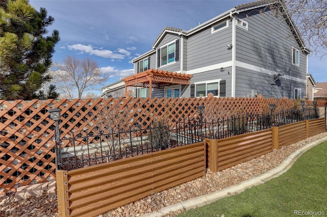 view of home's exterior with fence and a pergola