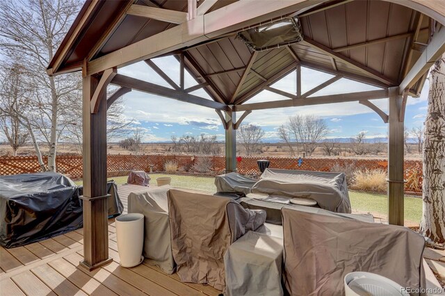 deck featuring a gazebo, outdoor lounge area, and fence