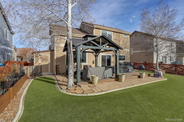 back of house featuring a gazebo, a fenced backyard, a patio, and a yard