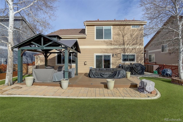 back of property featuring a deck, a gazebo, a lawn, and fence