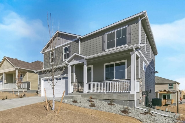 view of front of home featuring cooling unit, a garage, and covered porch