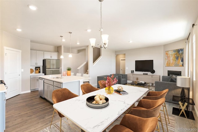 dining room featuring dark hardwood / wood-style floors, sink, and an inviting chandelier