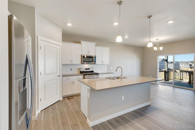 kitchen featuring white cabinetry, sink, pendant lighting, and appliances with stainless steel finishes