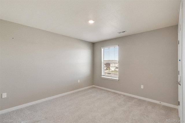 spare room featuring light carpet