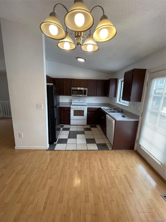 kitchen with white electric stove, black fridge, and light hardwood / wood-style flooring