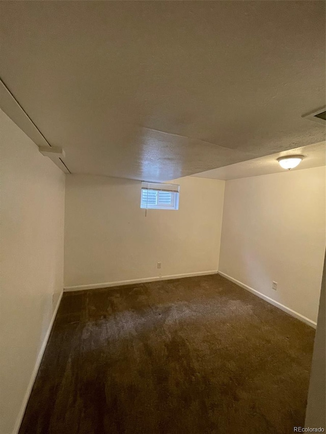 basement with dark colored carpet