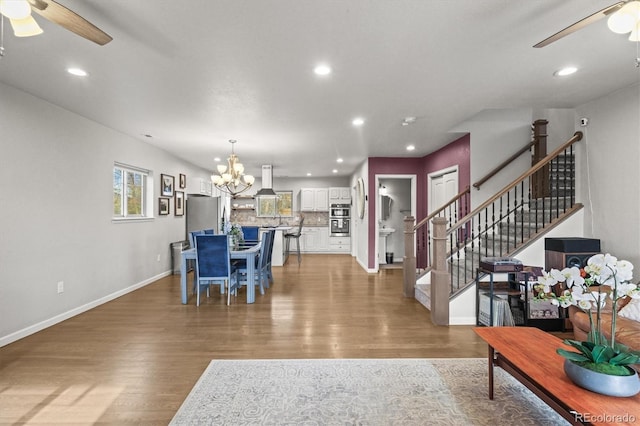 4942 Grove St, Denver, CO 80221 - living area featuring light wood-style flooring, ceiling fan with notable chandelier, baseboards, and recessed lighting