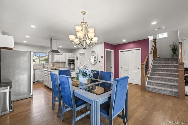 4942 Grove St, Denver, CO 80221 - dining room with an inviting chandelier, stairway, wood finished floors, and recessed lighting