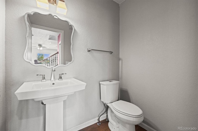 4942 Grove St, Denver, CO 80221 - bathroom featuring toilet, baseboards, and wood finished floors