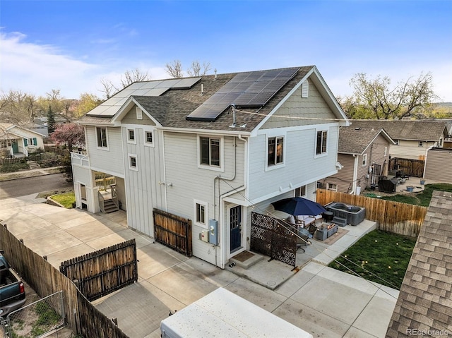 4942 Grove St, Denver, CO 80221 - rear view of property featuring a patio, solar panels, a residential view, a shingled roof, and a fenced backyard