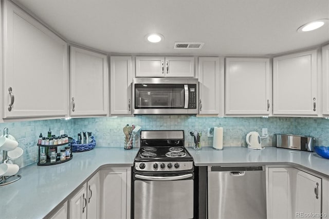 4942 Grove St, Denver, CO 80221 - kitchen with visible vents, decorative backsplash, light countertops, white cabinets, and appliances with stainless steel finishes