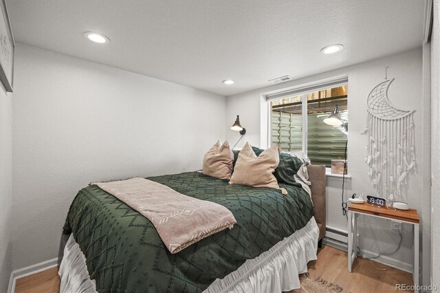 4942 Grove St, Denver, CO 80221 - bedroom with recessed lighting, baseboards, visible vents, and wood finished floors