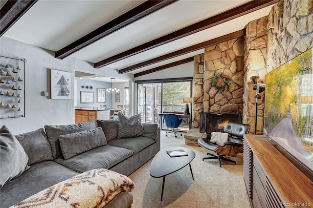 living room with lofted ceiling with beams, a stone fireplace, light colored carpet, and a chandelier