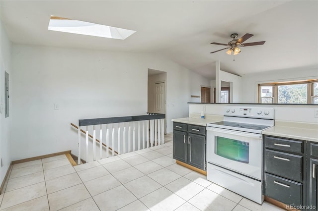 18 Clover Cir, Colorado Springs, CO 80906 - kitchen featuring electric range, vaulted ceiling, a skylight, light tile patterned flooring, and dark cabinetry