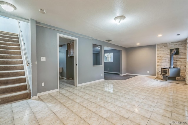 18 Clover Cir, Colorado Springs, CO 80906 - unfurnished living room with a wood stove, stairs, a textured ceiling, and tile patterned flooring